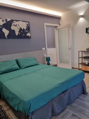 a bedroom with a large green bed with a map on the wall at Casa Teresa in Tricase
