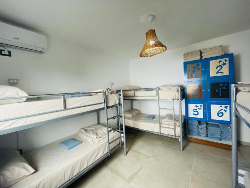 a room with three bunk beds and a lamp at Adriatic Hostel Vlora in Vlorë