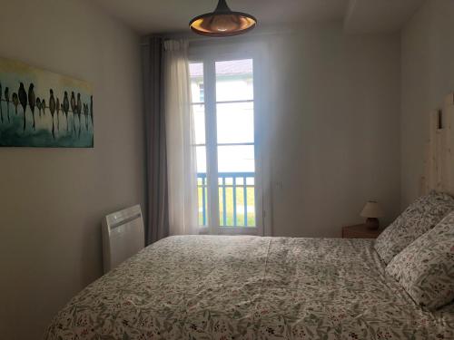 a bedroom with a large bed and a window at Grand appartement en RDC Vallée de Campan in Campan