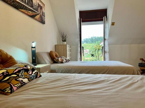 a hotel room with two beds and a window at Casa adosada en Argoños in Argoños