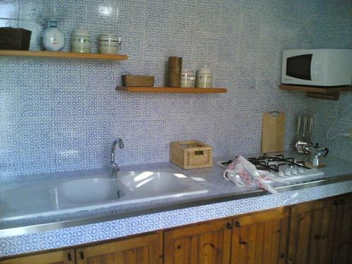 a kitchen counter with a sink and a microwave at Villa 2M a 50 metri dal mare in San Vito lo Capo