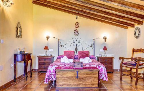 a bedroom with a bed and two tables and a chair at Aranzazu in Frigiliana