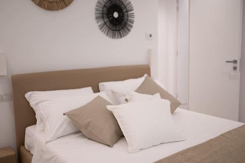 a white bed with white pillows and a mirror at DaNina in Verona