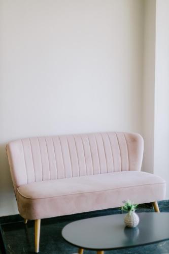 a pink couch in a living room with a table at Zephyros Hotel in Kos Town