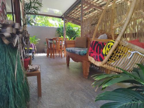 a swinging hammock in a room with a table at Tiki House in Bora Bora
