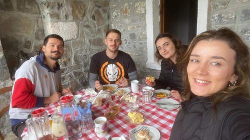 a group of people sitting around a table at Bujtina Carku in Theth