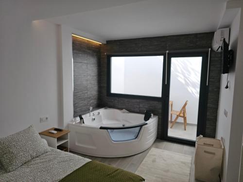 Cette chambre comprend une salle de bains pourvue d'une grande baignoire. dans l'établissement Alojamientos suite la morita, à Benalup-Casas Viejas