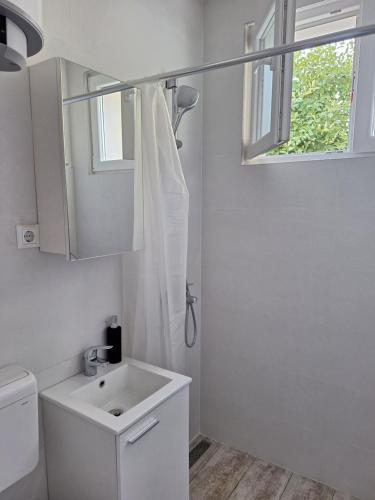 biała łazienka z umywalką i oknem w obiekcie Apartman Anchi w mieście Zadar