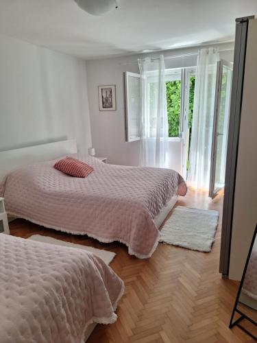 sypialnia z 2 łóżkami i drewnianą podłogą w obiekcie Apartman Anchi w mieście Zadar