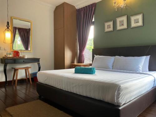a bedroom with a bed with a blue pillow on it at THE HIGHLANDS VILLA in Tanah Rata