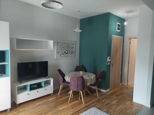 a dining room with a table with chairs and a television at Studio 357 Cetinje in Cetinje