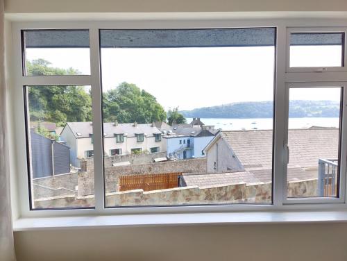 a window in a room with a view of a city at Crow's Nest Glandore - 3 - Self Catering in Glandore