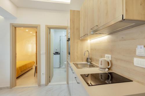 una piccola cucina con lavandino e una camera da letto di Apartmani Vasiljević a Herceg-Novi