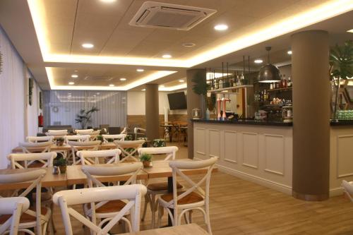 ein Restaurant mit Tischen und Stühlen und eine Bar in der Unterkunft Hotel Metropol in Lloret de Mar