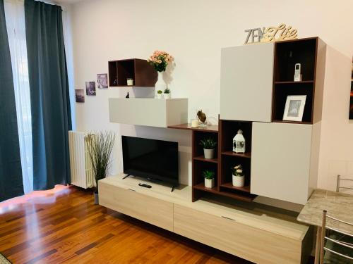 een woonkamer met een flatscreen-tv op een entertainmentcentrum bij Cosy New Apartment in Portello Certosa in Milaan