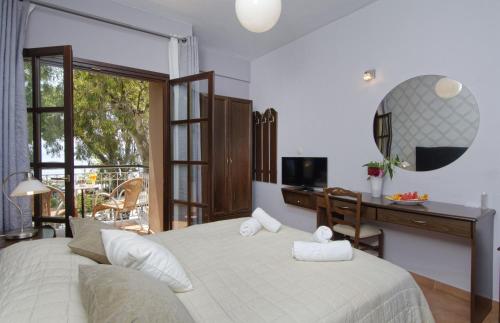 a bedroom with a large bed with a desk and a television at Enalion Hotel in Kala Nera