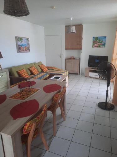 cocina y sala de estar con mesa y sofá en case an nou Martinique 3*** en Le Marin