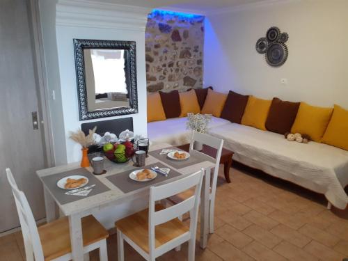 ein Wohnzimmer mit einem Tisch und einem Sofa in der Unterkunft Stone Clock's House in Nafpaktos