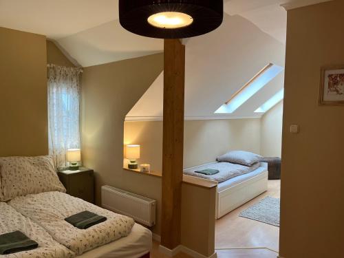 a bedroom with two twin beds and a window at Tulipán Villa Panzió in Szolnok