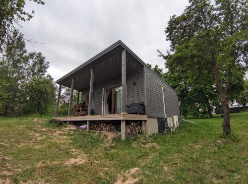 a small house sitting on a grass field at Obuoliu sala Moletu Vila in Gaylyunay