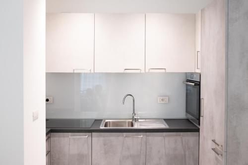 a kitchen with white cabinets and a sink at DaNina in Verona