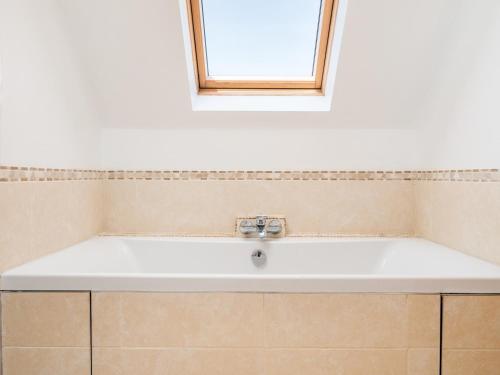 een witte wastafel in een badkamer met een raam bij Pass the Keys The Sculptors Cottage in Aylesbury