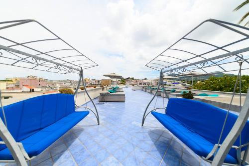 a couple of blue chairs on the roof of a building at Hotel Terme Oriente - Beach & SPA in Ischia