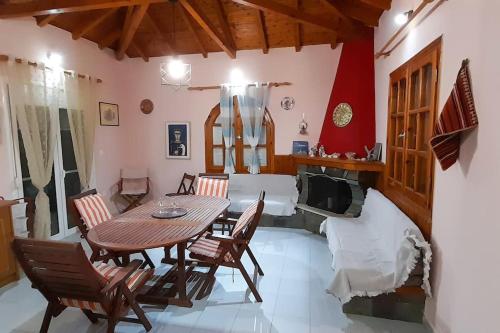 a room with a table and chairs and a bed at Tranquility Base in Neapoli Voion