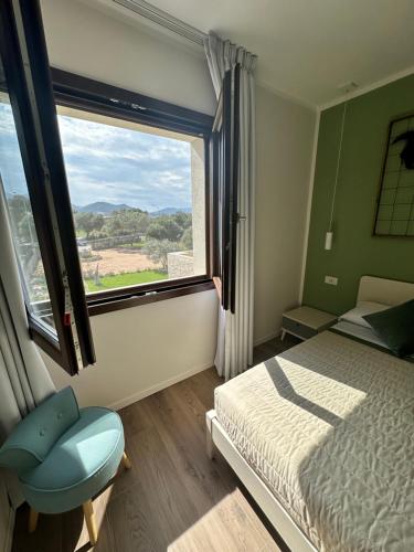 a bedroom with a bed and a window and a chair at Karasole in San Teodoro