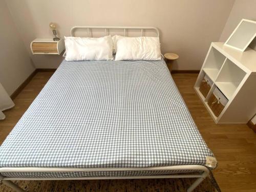 a bed in a room with a white shelf at Apartamento Solpor in Vilagarcia de Arousa