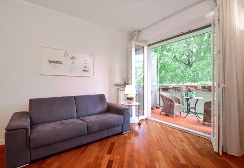 uma sala de estar com um sofá e uma porta de vidro deslizante em MiCo GARDEN VIEW CITYLIFE EXECUTIVE APARTMENT em Milão