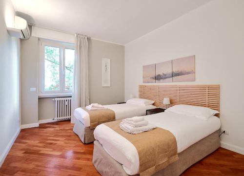 sypialnia z 2 łóżkami i oknem w obiekcie MiCo GARDEN VIEW CITYLIFE EXECUTIVE APARTMENT w Mediolanie