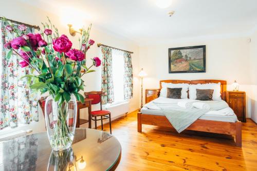 a bedroom with a bed and a vase of flowers on a table at Sv. Hubertus in Český Krumlov