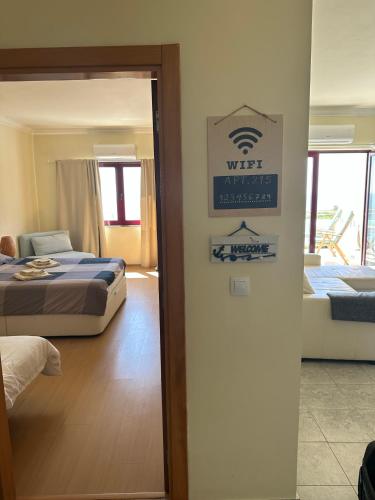 a hotel room with two beds and a sign on the wall at Ericeira Sea&Sun Apartment 3 in Ericeira