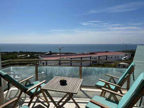 a balcony with chairs and a table and a train at Ericeira Sea&Sun Apartment 3 in Ericeira