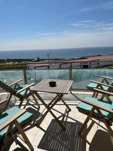 a table and chairs on a balcony with a train at Ericeira Sea&Sun Apartment 3 in Ericeira