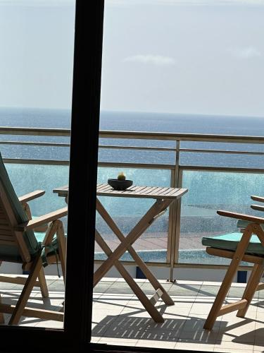 a table and chairs on a balcony with the ocean at Ericeira Sea&Sun Apartment 3 in Ericeira