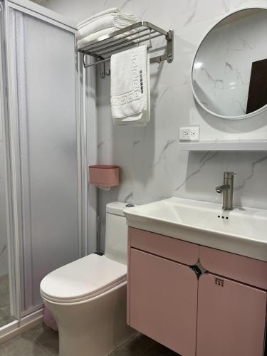 a bathroom with a toilet and a sink and a mirror at 易宿輕旅民宿Easy Go B&B in Huxi