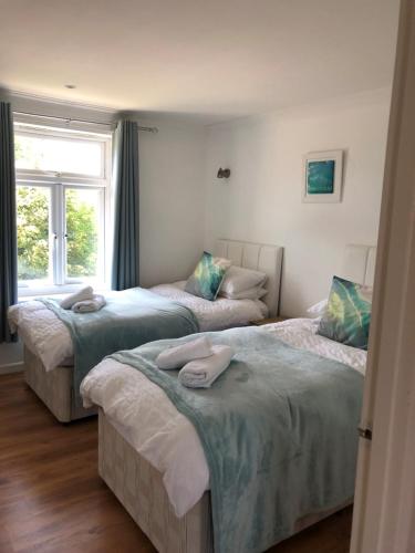 a bedroom with two beds with towels on them at Waves in Saint Columb Major