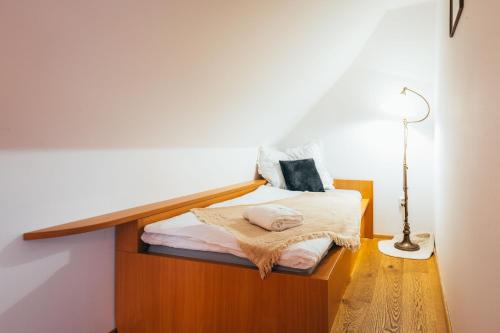a small bedroom with a bed with a lamp at Sv. Hubertus in Český Krumlov