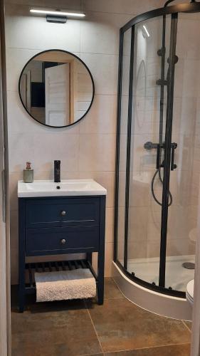 W łazience znajduje się umywalka oraz prysznic z lustrem. w obiekcie Domki Wysokie Trawy Zdory w Piszu
