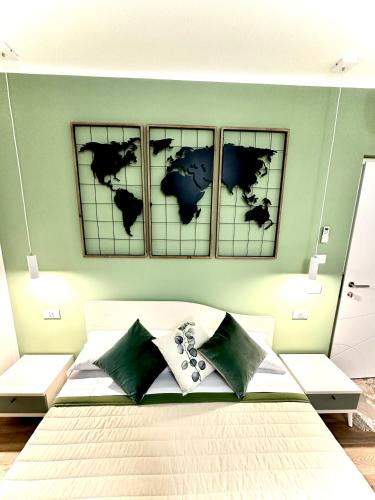a bedroom with four maps on the wall at Karasole in San Teodoro