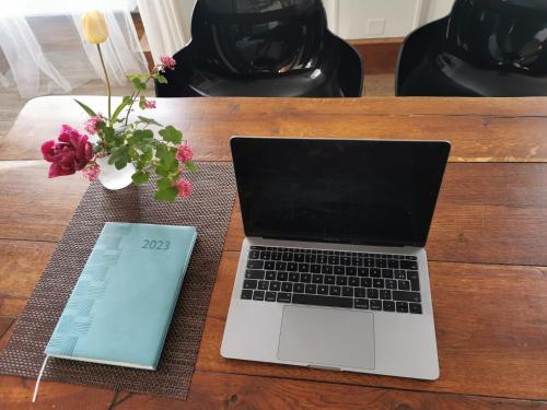 laptopa siedzącego na drewnianym stole w obiekcie Chez Kahina ancien hôtel Robert w mieście Giat