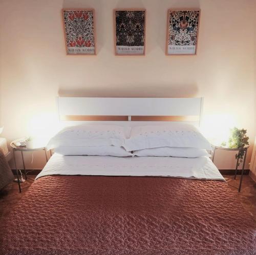 1 cama en un dormitorio con 2 cuadros en la pared en Casa Viola a 900 mt dalla Staz. Centrale en Pescara