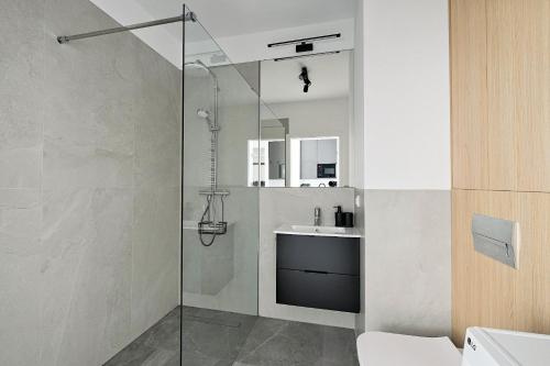 a bathroom with a shower and a sink at Optyków 3A Cozy Studio Promenada in Warsaw