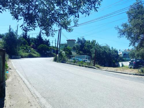 an empty street with cars parked on the side of the road at Yard Paradise in Dhërmi