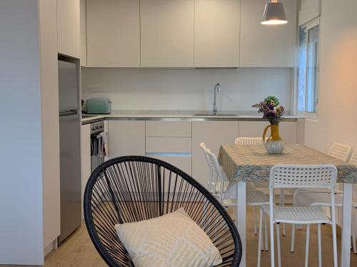 a kitchen with a table and chairs and a kitchen with white cabinets at Ana Apartamento Turístico in Arróniz