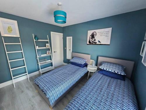 Jubilee House في نيوارك أبون ترينت: سريرين في غرفة نوم بجدران زرقاء