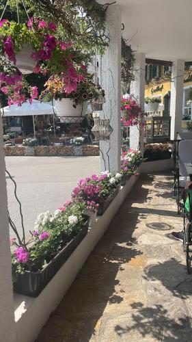 a row of flowerpots on the side of a building with flowers at Hotel Radetzky in Sankt Gilgen