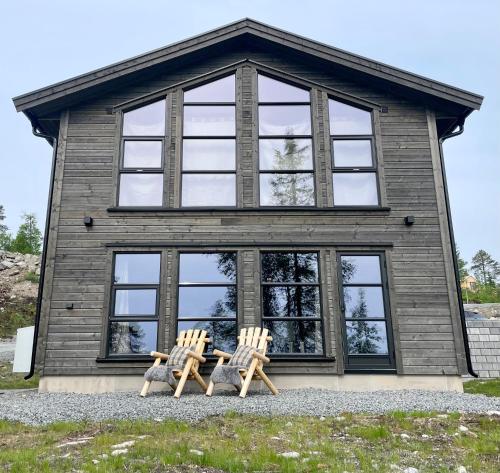 duas cadeiras sentadas em frente a uma casa em Norebu - Norefjell em Noresund